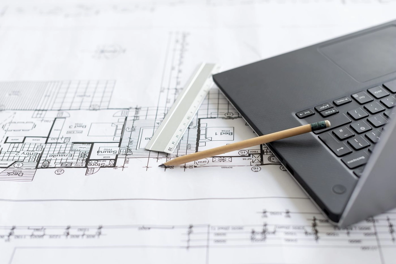 Analyse et traçage de plans architecturaux sur bureau.